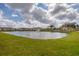Scenic view of a pond surrounded by lush greenery and residential buildings at 1110 Villagio Cir # 103, Sarasota, FL 34237
