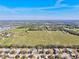 An aerial view showcases homes backing to a large green field under a clear blue sky at 11213 2Nd E Ave, Bradenton, FL 34212