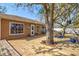 Charming backyard featuring a wooden deck, mature trees, and outdoor seating area for relaxation at 11213 2Nd E Ave, Bradenton, FL 34212