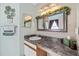 Cozy bathroom with a marble countertop, decorative ivy, framed mirror and vanity lighting at 11213 2Nd E Ave, Bradenton, FL 34212