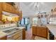 Cozy kitchen showcasing stainless sink, stove, wooden cabinets, and an open view to the living area at 11213 2Nd E Ave, Bradenton, FL 34212