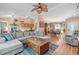Spacious living room featuring a large sectional sofa, hardwood floors, and an open layout to dining area at 11213 2Nd E Ave, Bradenton, FL 34212