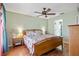 Serene main bedroom with a ceiling fan, wood flooring, and a view into the ensuite bathroom at 11213 2Nd E Ave, Bradenton, FL 34212