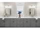 Bathroom with double vanity, grey cabinetry, ample counter space, framed mirrors, and decorative lighting at 11553 11Th E Ave, Bradenton, FL 34212