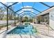 Outdoor pool area with enclosed screen, adjacent patio, and jacuzzi at 11553 11Th E Ave, Bradenton, FL 34212