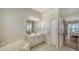 Bright bathroom with double sinks, tiled flooring, and view of the Primary bedroom at 129 Wayforest Dr, Venice, FL 34292