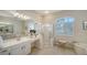 Well-lit bathroom with large shower, jacuzzi tub, make up vanity and tile flooring at 129 Wayforest Dr, Venice, FL 34292