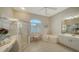 Spacious bathroom featuring a jacuzzi tub, large shower, tile flooring, and make up vanity at 129 Wayforest Dr, Venice, FL 34292