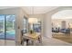 Bright breakfast nook features a view of the lanai and pool with stylish table and chairs at 129 Wayforest Dr, Venice, FL 34292