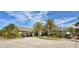 The charming clubhouse entrance is framed by swaying palm trees and manicured landscaping, blending luxury and nature at 129 Wayforest Dr, Venice, FL 34292