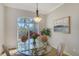 Elegant dining room with a glass table, comfortable seating, and a view of the lush outdoors at 129 Wayforest Dr, Venice, FL 34292