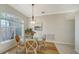 Bright dining room with a round glass table, elegant chairs, and a large window at 129 Wayforest Dr, Venice, FL 34292