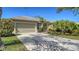 Charming home featuring lush landscaping and a spacious driveway leading to an attached two-car garage at 129 Wayforest Dr, Venice, FL 34292