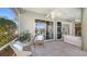 Covered outdoor patio with brick flooring, ceiling fans and neutral furniture overlooking the pool at 129 Wayforest Dr, Venice, FL 34292