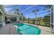 Relaxing screened-in pool with brick patio, lush landscaping, and clear blue water to enjoy swimming at 129 Wayforest Dr, Venice, FL 34292