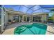 Inviting screened-in pool with covered patio, brick flooring, and lounge seating area at 129 Wayforest Dr, Venice, FL 34292