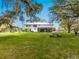 Expansive backyard featuring a two-story home with a covered patio, outdoor seating, and lush green grass at 15101 Rawls Rd, Sarasota, FL 34240