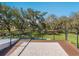 Deck with steel rails and hardwood floors overlooks a green backyard with mature trees at 15101 Rawls Rd, Sarasota, FL 34240