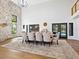 Bright dining room with stone accent wall, hardwood floors, large table, and modern light fixtures at 15101 Rawls Rd, Sarasota, FL 34240