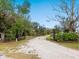 Picturesque gated driveway with a winding path through lush greenery and mature trees at 15101 Rawls Rd, Sarasota, FL 34240