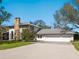 Charming home with a stone chimney, a three-car garage, and a well-maintained lawn and driveway at 15101 Rawls Rd, Sarasota, FL 34240
