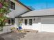 Close-up of the home's entrance with double doors, a gray roof, and a three-car garage at 15101 Rawls Rd, Sarasota, FL 34240