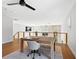 Open loft features a study area with wood floors, stone accent wall, and bright natural light from multiple windows at 15101 Rawls Rd, Sarasota, FL 34240