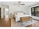 A spacious bedroom boasts a stylish bed, bench, and nightstands over wood floors, and plenty of light from a large window at 15101 Rawls Rd, Sarasota, FL 34240