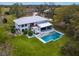 Aerial view of a modern two-story home with a backyard pool, lounge area, and outdoor dining at 15101 Rawls Rd, Sarasota, FL 34240