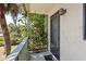 Welcoming entryway from the balcony with verdant trellis and a potted plant stand, blending indoor/outdoor living at 1519 Pelican Point Dr # 288, Sarasota, FL 34231
