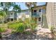 Condo building featuring lush landscaping, stairs leading to the entry door, and balconies in a beautiful setting at 1519 Pelican Point Dr # 288, Sarasota, FL 34231