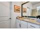 Bathroom vanity featuring granite countertops, modern fixtures, framed mirror, and access to the glass enclosed shower at 16111 Sunny Day Dr, Bradenton, FL 34211