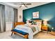 Tastefully decorated bedroom with a blue accent wall, modern furnishings, and a ceiling fan at 16111 Sunny Day Dr, Bradenton, FL 34211
