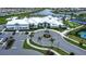 Aerial view of the community clubhouse featuring a pool, parking, and verdant landscaping in a serene setting at 16111 Sunny Day Dr, Bradenton, FL 34211