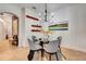 Dining room featuring a glass table and four upholstered chairs beneath a modern chandelier at 16111 Sunny Day Dr, Bradenton, FL 34211