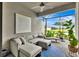 Enjoy the covered patio with an outdoor lounge area, rug, fan, and peaceful view of the green space at 16111 Sunny Day Dr, Bradenton, FL 34211