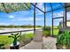 Inviting screened patio with lounge chair, umbrella, and view of the backyard pond at 16111 Sunny Day Dr, Bradenton, FL 34211