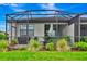 View of a screened patio area with outdoor furniture and well-manicured backyard at 16111 Sunny Day Dr, Bradenton, FL 34211