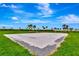 Inviting sand volleyball court surrounded by green grass and palm trees for active community fun at 16111 Sunny Day Dr, Bradenton, FL 34211