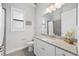 Bathroom features a granite vanity, white cabinets, and a tiled shower at 17519 Polo Trl, Lakewood Ranch, FL 34211