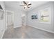 Bright bedroom features wood-look tile flooring, ceiling fan, and walk-in closet at 17519 Polo Trl, Lakewood Ranch, FL 34211