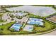 Aerial view of a community center with pool, tennis courts, and a lake at 17519 Polo Trl, Lakewood Ranch, FL 34211