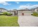Beautiful single-story home featuring a tile roof, three-car garage, paver driveway and lush landscaping at 17519 Polo Trl, Lakewood Ranch, FL 34211