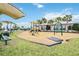 Community playground with covered play structures and shade, set near lush landscaping and seating areas at 17519 Polo Trl, Lakewood Ranch, FL 34211