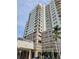 Beautiful condominium building featuring multiple balconies, a portico, and lush landscaping at 1771 Ringling Blvd # 902, Sarasota, FL 34236