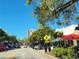 Vibrant street view with lush trees, cafes, and clear blue sky promoting an inviting urban lifestyle at 1771 Ringling Blvd # 902, Sarasota, FL 34236