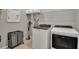 Well-organized laundry room with modern washer and dryer, storage shelves, and ample space at 18010 Harwich Pl, Lakewood Ranch, FL 34202