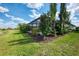Landscaped backyard featuring a screened-in patio and pool area, surrounded by tropical foliage at 18032 Polo Trl, Bradenton, FL 34211