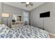 This is a cozy bedroom featuring a patterned quilt, neutral walls, and a ceiling fan at 18032 Polo Trl, Bradenton, FL 34211