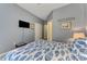 This is a comfortable bedroom with a patterned quilt, neutral walls, closet and a TV at 18032 Polo Trl, Bradenton, FL 34211